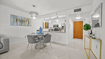 A modern kitchen with white cabinets, stainless steel appliances, and a central island.