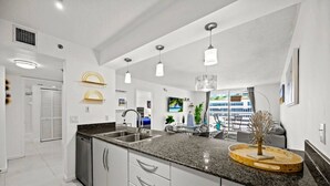 A modern kitchen with granite countertops, stainless steel appliances, and pendant lighting. - Splendid Unit with Parking in Brickell Miami (Miami)