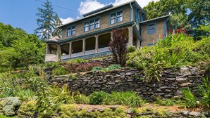 A two-story house with a stone retaining wall and lush garden. - Rent the Entire Historic Inn in Downtown Marshall (Marshall)