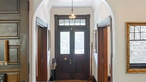 A hallway with wooden floors, a rug, and a dark wooden door at the end. - Rent the Entire Historic Inn in Downtown Marshall (Marshall)