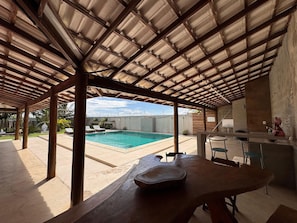 A covered outdoor area with a pool, a table, and chairs. - Casa Marataizes (Marataizes)