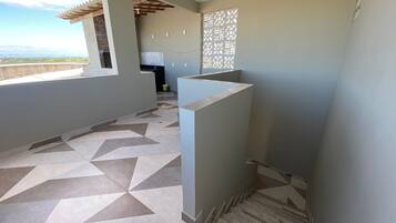 Um interior moderno com um chão estampado em padrão geométrico, uma área de cozinha e vista pela janela.