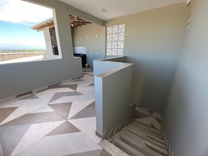 A modern interior with a geometric patterned floor, a kitchen area, and a view through a window. - Casa Marataizes (Marataizes)