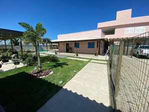 Enjoy a home with a modern design, a lawn, a swimming pool, and a fenced area.