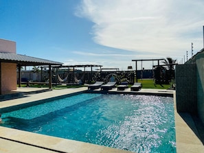 A swimming pool with lounge chairs and a covered seating area. - Casa Marataizes (Marataizes)