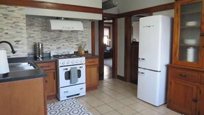 Une cuisine équipée d’une cuisinière, d’un four, d’un évier et d’un réfrigérateur.