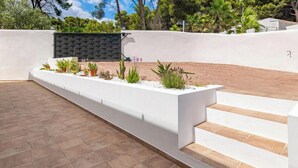 A modern outdoor area with a white planter box, steps, and a black fence. - Villa Milana • Sea views & Beach vibes (Moraira)