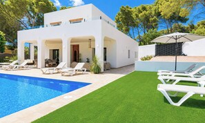 Une maison moderne Ă deux Ă©tages, dotĂ©e dâune piscine, dâun espace salon extĂ©rieur et dâune pelouse bien entretenue.