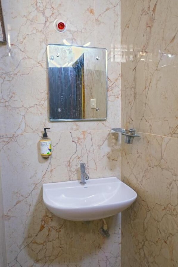 Ein Badezimmer mit Waschbecken, Spiegel und Seifenspender.