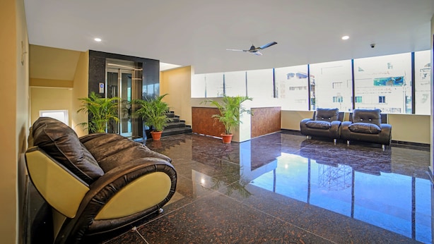 A modern lobby with a reception desk, seating area, and a view of the outside. - Staro Hotel - Hotel In Vijayawada (Vijayawada)