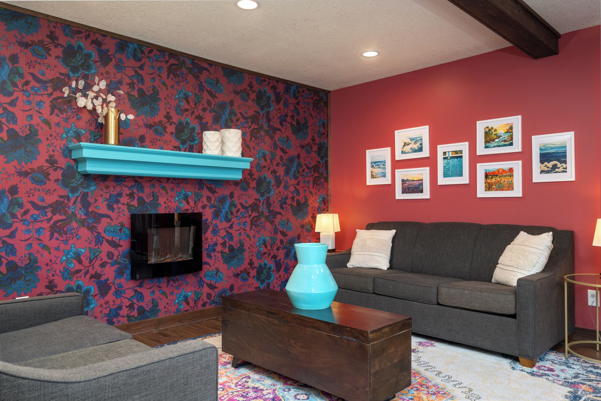 A living room with a fireplace, a sofa, a coffee table, and a wall with framed pictures.