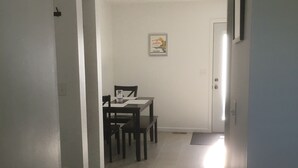 En hall som leder till ett matområde med ett bord och stolar.