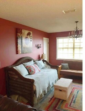 A cozy room with a wicker sofa, a bench, and a colorful rug. - Robins Nest "The Best Nest In Town"  Newly Remodeled Master Bath. (Murfreesboro)