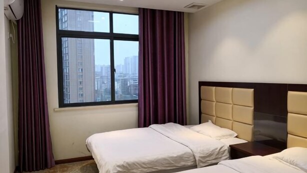 Une chambre d’hôtel avec deux lits, une grande fenêtre et une vue sur la ville.
