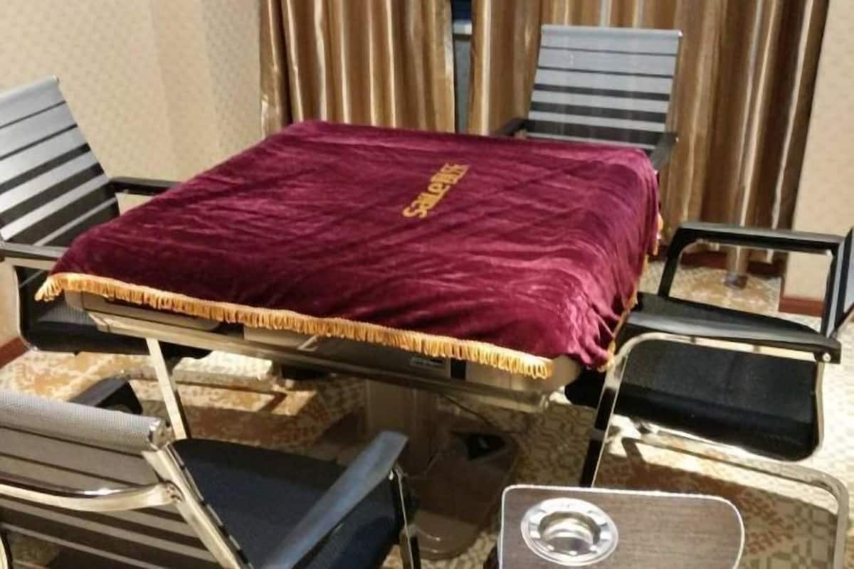 Een kamer met een bed, een tafel en twee stoelen.