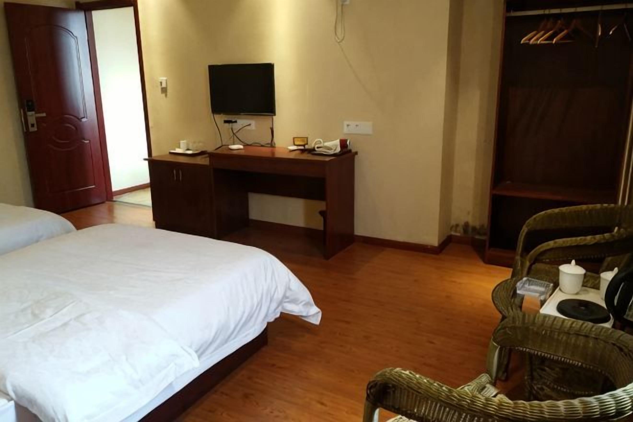 A bedroom with a bed, a desk, a chair, and a wardrobe.