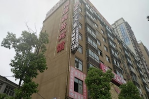 A multi-story building with a prominent red sign on the side. - Fushangshangwubingguan (Yangxin)