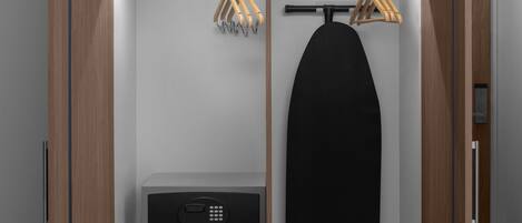 A walk-in closet with a hanging iron, a small appliance, and wooden hangers.