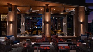 An outdoor seating area with modern furniture, large pillars, and ceiling fans. - Element by Marriott San Antonio Riverwalk (San Antonio)