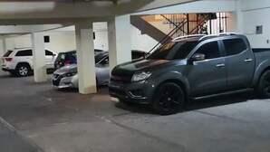 A parking garage with multiple cars parked under concrete pillars. - Apartamento en el centro de la ciudad (La Romana)
