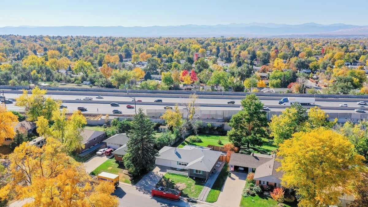 Una zona residencial con casas, una autopista y follaje otoñal.