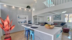 A modern kitchen with a central island, bar stools, and a potted plant. - The Perros house - PERROS GUIREC (PERROS GUIREC)