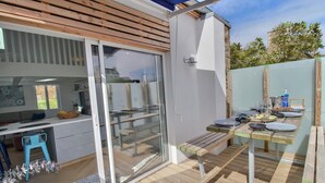 A modern outdoor kitchen area with a sliding glass door leading to a patio. - The Perros house - PERROS GUIREC (PERROS GUIREC)