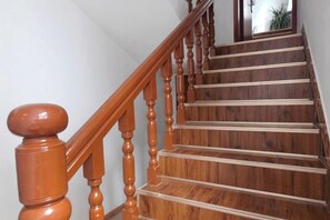 A wooden staircase with a handrail and a mirror on the wall. - Shanhai Coffee Inn (Zhangjiajie)
