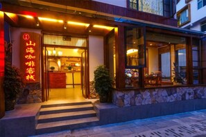A restaurant with a stone facade, a wooden entrance, and a sign with Chinese characters. - Shanhai Coffee Inn (Zhangjiajie)