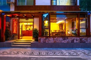 Un edificio con facciata in pietra, ingresso in legno e interni ben illuminati.
