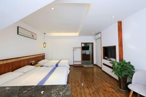 A hotel room with a bed, a TV, a plant, and a wooden floor. - Shanhai Coffee Inn (Zhangjiajie)