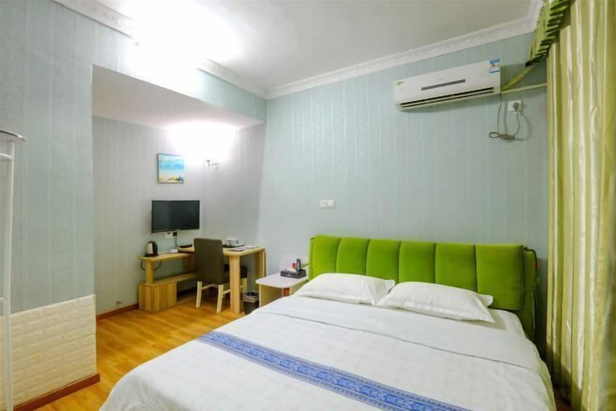Une chambre d’hôtel équipée d’un lit, d’un bureau avec une chaise, d’une télévision et d’un appareil de climatisation.