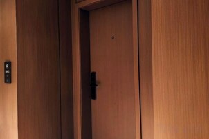 Una puerta de madera con un pomo y un pequeño cartel en la pared a la izquierda.