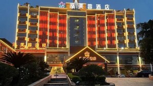 Un hotel con varios pisos, una entrada destacada y una fachada bien iluminada.