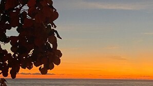 Una vista al atardecer con playa y océano.