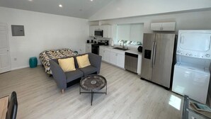 A modern apartment with a kitchenette, a sofa, a dining table, and a large window. - ENTIRE MODERN LUXURY STUDIO PRIVATE FOR UP TWO PEOPLE AT WEST HIILS  (Los Angeles)
