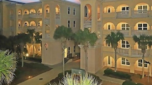 Un hôtel à plusieurs étages, doté d’une façade symétrique, de nombreux balcons et d’une cour intérieure agrémentée de palmiers.