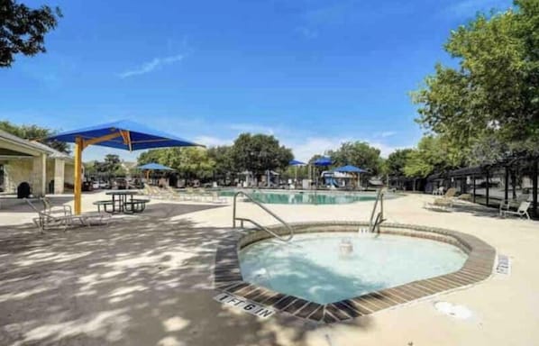 A pool area with multiple pools, sun loungers, and umbrellas.