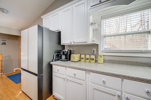 Enjoy cooking in this well-equipped kitchen with a refrigerator, coffee maker, and ample counter space.