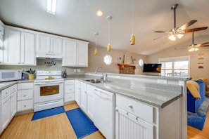 Enjoy cooking in this well-lit kitchen with an oven, large island, and sink.