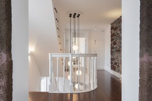 Ein modernes Interieur mit einer Holztreppe, weißen Wänden und einer Wand aus Ziegelsteinen.