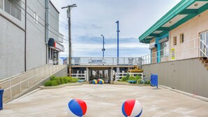 Un espace de stationnement avec deux ballons de plage, un panneau indiquant l’avenue Maple et un vélo.