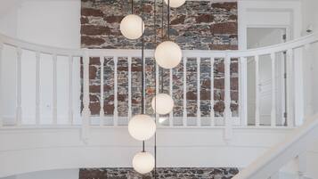 A staircase with a white railing and a stone wall.