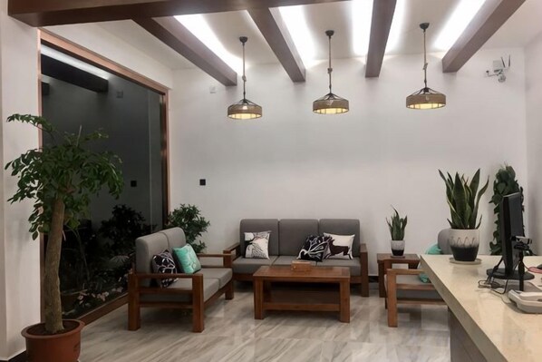 Una sala moderna con sofá, mesa de centro y lámparas colgantes.