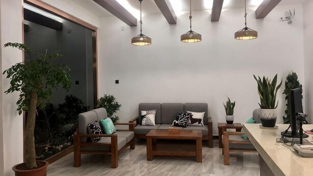 A modern living room with a sofa, coffee table, and hanging lights. - Puxin Inn (Dali City)