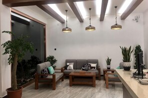 A modern living room with a sofa, coffee table, and hanging lights. - Puxin Inn (Dali City)