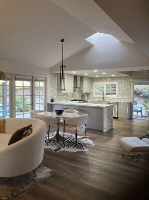 A modern kitchen with a central island, pendant lighting, and a view to the outdoors. - Modern Luxe Retreat !! (Santa Clarita)