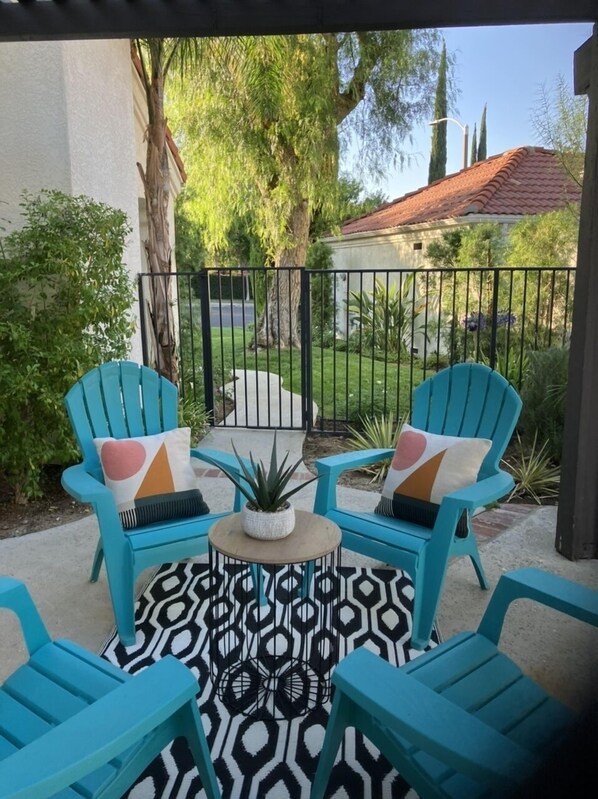 A patio with turquoise chairs, a patterned rug, and a small table with a plant. - Modern Luxe Retreat !! (Santa Clarita)