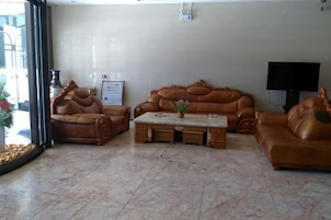 Una sala de estar con sofás de cuero, una mesa de centro y un televisor.
