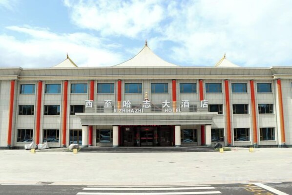 A hotel with a modern facade, multiple floors, and a prominent entrance.